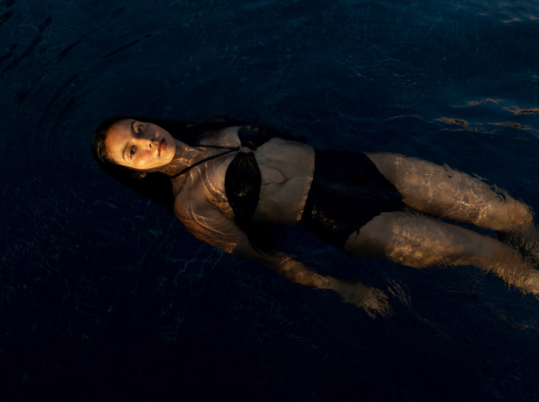 Person lying on the water surface at night in swimwear, swimsuit for women, swimdresses, swimwear India