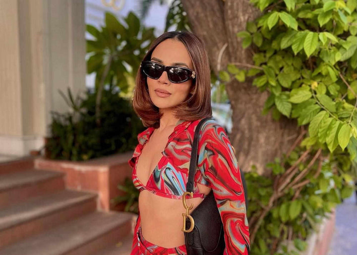 Woman wearing red printed cayenne wave ruffled sleeve top and ruched skirt and bikini top, swimwear for women, resort wear for ladies, sarong, izsi India